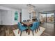 Bright dining room with a wooden table, blue chairs, and access to the balcony at 240 Sand Key Estates Dr # 58, Clearwater Beach, FL 33767