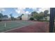 View of a community tennis court with lighting and fenced perimeter at 2424 W Tampa Bay Blvd # A106, Tampa, FL 33607
