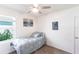 Bright bedroom featuring a ceiling fan, and a twin bed near a window with beach-themed wall decor at 25317 E Lenox Cir, Punta Gorda, FL 33950
