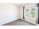Carpeted bedroom featuring a sun-lit window with tree views and gray and black curtains at 25317 E Lenox Cir, Punta Gorda, FL 33950