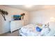 Bright bedroom featuring palm tree wall decor and a TV atop a white dresser at 25317 E Lenox Cir, Punta Gorda, FL 33950