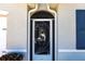 A closeup of the front door featuring an ornamental screen door with decorative dolphin design at 25317 E Lenox Cir, Punta Gorda, FL 33950