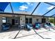 Screened patio with travertine flooring, stylish seating, and views of the pool and landscaped yard at 25317 E Lenox Cir, Punta Gorda, FL 33950