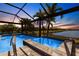 Inviting screened pool and spa with beautiful stone tile, set against a waterfront view at 25317 E Lenox Cir, Punta Gorda, FL 33950