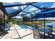 Inviting screened-in pool area featuring a scenic lake view, comfortable seating, and lush landscaping at 25317 E Lenox Cir, Punta Gorda, FL 33950