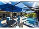 Beautiful pool area with travertine flooring, comfortable seating, and a picturesque lake view under a screened enclosure at 25317 E Lenox Cir, Punta Gorda, FL 33950