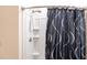 Close up of a white tiled shower with a gray patterned shower curtain at 25317 E Lenox Cir, Punta Gorda, FL 33950