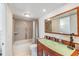 Bathroom featuring vanity with green glass countertop, soaking tub, and tile surround at 2616 Cove Cay Dr # 301, Clearwater, FL 33760