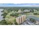 Aerial view of condo buildings near golf courses, ponds, parking, and verdant landscaping at 2616 Cove Cay Dr # 301, Clearwater, FL 33760