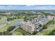 Aerial view of condo buildings close to a golf course, pond, lush landscaping and parking at 2616 Cove Cay Dr # 301, Clearwater, FL 33760