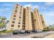 Tall condominium building featuring balconies and a well-maintained parking area at 2616 Cove Cay Dr # 301, Clearwater, FL 33760