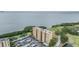 Exterior aerial view of a waterfront condo surrounded by lush landscaping, a golf course, and the bay at 2616 Cove Cay Dr # 301, Clearwater, FL 33760