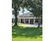 Exterior view of a building with large windows, surrounded by lush greenery and mature trees at 2616 Cove Cay Dr # 301, Clearwater, FL 33760