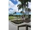 Picturesque golf course view with palm trees, a water feature, outdoor seating, and a wooden bridge at 2616 Cove Cay Dr # 301, Clearwater, FL 33760
