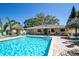 Enjoy the community pool with sun loungers, tiki hut umbrellas and a building with 1200 marked on the wall at 2616 Cove Cay Dr # 301, Clearwater, FL 33760