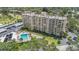An aerial view showcasing a high-rise condo building with a pool, hot tub, and lush landscaping at 2621 Cove Cay Dr # 204, Clearwater, FL 33760