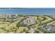 Aerial view featuring condos nestled beside a golf course with a bridge and bay in the background at 2621 Cove Cay Dr # 204, Clearwater, FL 33760