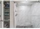 Modern shower with marble-look tile and sliding glass door, complemented by convenient built-in shelving at 2621 Cove Cay Dr # 204, Clearwater, FL 33760