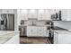 Kitchen with stainless steel appliances, white cabinets, stone countertops and dark floors at 2621 Cove Cay Dr # 204, Clearwater, FL 33760