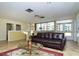 Comfortable living room with a leather sofa and large windows offering views of the community pool area at 2621 Cove Cay Dr # 204, Clearwater, FL 33760