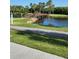 Scenic view of a wooden bridge crossing a serene pond surrounded by lush greenery and palm trees at 2621 Cove Cay Dr # 204, Clearwater, FL 33760