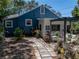 Charming blue home featuring a stone patio with plentiful foliage and backyard seating at 3001 9Th N Ave, St Petersburg, FL 33713