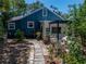 Charming blue home featuring a stone patio with plentiful foliage and backyard seating at 3001 9Th N Ave, St Petersburg, FL 33713