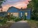 Charming blue bungalow with a lush garden and a cozy front porch at sunset at 3001 9Th N Ave, St Petersburg, FL 33713