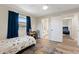 Bright bedroom with wood floors, a window with curtains, and a view of the en suite bathroom and another bedroom at 3112 65Th N Way, St Petersburg, FL 33710