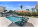 Backyard pool featuring clear water, lounge chairs, an umbrella, and a landscaped yard at 3112 65Th N Way, St Petersburg, FL 33710