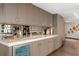 Wet bar with mirrored backsplash, marble countertop, custom wood cabinetry, and beverage fridge at 3301 Bayshore Blvd # 2401E, Tampa, FL 33629