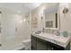 Bathroom featuring a glass shower and marble counters with decorative sconces and artwork at 3301 Bayshore Blvd # 2401E, Tampa, FL 33629