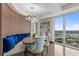 Bright dining area featuring a built-in booth with blue pillows, a modern chandelier, and a stunning city view at 3301 Bayshore Blvd # 2401E, Tampa, FL 33629