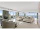 Bright living room featuring tile flooring, walls of windows with water views, and stylish neutral furniture at 3301 Bayshore Blvd # 2401E, Tampa, FL 33629