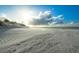 Wide sandy beach with a blue sky and wispy clouds as the sun shines brightly at 333 Island Way # 203, Clearwater Beach, FL 33767