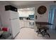 Functional kitchen featuring white cabinets, appliances, and a breakfast bar with stools, ideal for casual dining at 333 Island Way # 203, Clearwater Beach, FL 33767