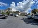 Exterior view of parking lot near building with a nicely landscaped area and cloudy skies at 333 Island Way # 203, Clearwater Beach, FL 33767
