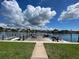 Scenic waterfront featuring a wooden dock and lush green lawn, ideal for tranquil enjoyment and recreation at 333 Island Way # 203, Clearwater Beach, FL 33767
