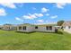 Exterior view of the home's backyard featuring a lawn and white walls at 3545 97Th N Ave # 4, Pinellas Park, FL 33782