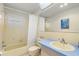 Bathroom with a shower-tub combo, blue vanity, and wallpapered walls at 3545 97Th N Ave # 4, Pinellas Park, FL 33782