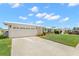 Exterior view of a white home with a spacious driveway and well-maintained lawn at 3545 97Th N Ave # 4, Pinellas Park, FL 33782