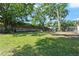 Large backyard with mature trees, a brick fence, and ample green space for recreation and relaxation at 3910 W Comanche Ave, Tampa, FL 33614