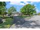 A single-story home nestled among mature trees, boasting a well-maintained lawn and circular driveway at 3910 W Comanche Ave, Tampa, FL 33614