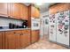 Kitchen with built in oven, wood cabinets, granite countertop, and an adjacent refrigerator at 3910 W Comanche Ave, Tampa, FL 33614