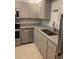 Well-lit kitchen with granite countertops, stainless steel dishwasher, and white cabinetry at 400 64Th Ave # 202, St Pete Beach, FL 33706
