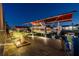 Illuminated boat dock featuring a covered boat lift and lush landscaping in a waterfront setting at twilight at 4011 99Th W St, Bradenton, FL 34210