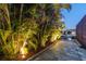 Beautiful waterfront property with tropical landscaping and private dock illuminated for evening enjoyment at 4011 99Th W St, Bradenton, FL 34210