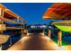 A waterfront property at dusk, with multiple boat lifts and illuminated docks for nighttime enjoyment at 4011 99Th W St, Bradenton, FL 34210