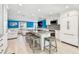 A full view of the open kitchen with white cabinetry, a center island with seating, and light-filled living spaces at 4011 99Th W St, Bradenton, FL 34210