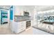 A modern kitchen with stainless steel appliances, white cabinets, and views of the pool and outdoor dining area at 4011 99Th W St, Bradenton, FL 34210